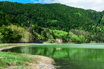 Azores, Portugal. Beautiful lake lagoa do Furnas with old church among the mountains on San Miguel Island
