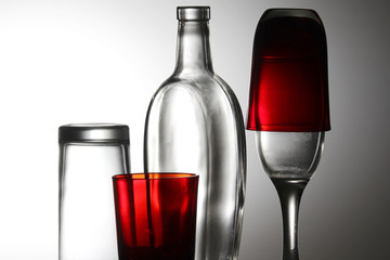 A transparent bottle and red glasses