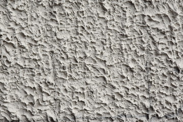 Stucco applied by machine method, rough smears. Grey colour