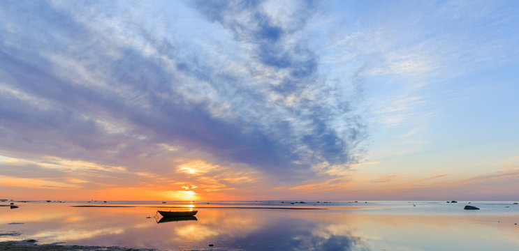 Fototapeta Baltic sea - early morning golden sunrise over the sea. Fishing boats on the sea against the background of sunrise and sunlight. Kurzeme, Latvia