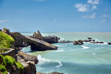 Biarritz city and view of its the famous landmark Rocher de la Vierge, a statue of Virgin Mary on the rock. Bay of Biscay, Atlantic coast, Basque country, France. Summer sunny day with white clouds