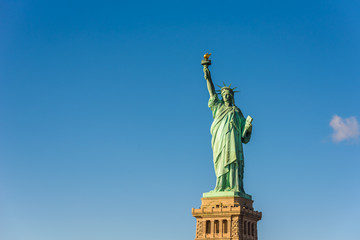 Obraz premium Statua Wolności w słoneczny dzień z błękitnym niebem, Nowy Jork, USA