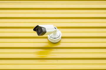 Surveillance video camera isolated on yellow