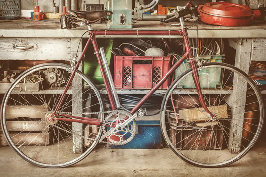 Fototapeta Vintage racing bycicle in front of an old work bench with tools