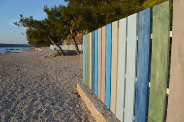 Kolorowy drewniany płot na kamienistej plaży, Chorwacja