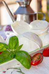 Fresh soft Italian white cheese mozzarella buffalo, original from Campania, Paestrum and Foggia regions, South Italy, served with tomatoes and fresh basil