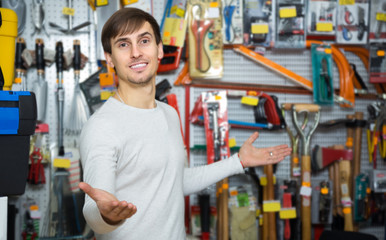 Young male seller posing at tooling section