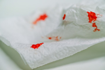 Red blood on tissue toilet paper. Health care concept.