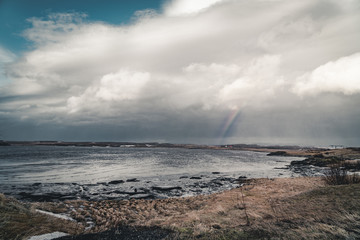 Iceland typical mountain winter scene with grass in foreground and massive mountain in background.