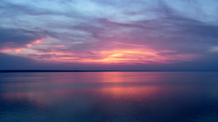 Beautiful pink sunset with sun rays over sea.