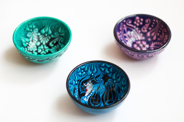 Three small bowls with turkish design, white background, selective focus