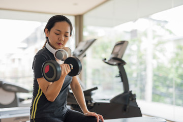 Woman exercise dumbbell in sport gym