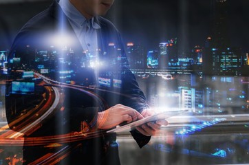 double exposure of handsome business man using mobile tablet with modern night city background, financial, investment, cyber, security system, network technology, internet and digital concept