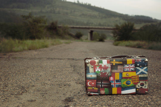 Vintage suitcase with collection of retro flag