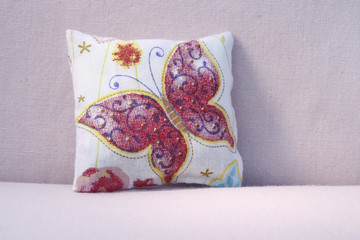 Fototapeta na wymiar Red butterfly pillow on the sofa