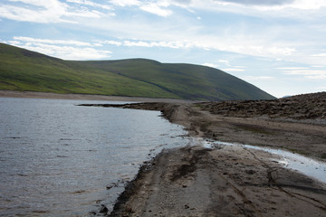 Looking eastwards at a section of muddy road that is normally submerged under Loch Glascarnoch