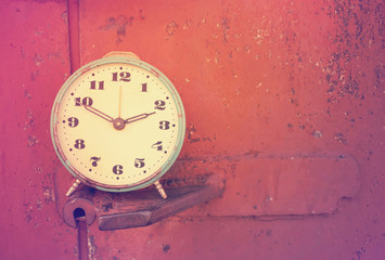 Blue Vintage retro alarm clock on against the background of rusty brown metal wall with copy space....
