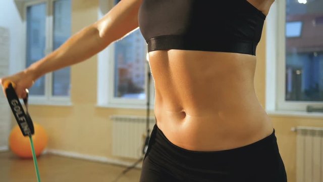 Athletic girl is engaged in crossfire, A young athlete is engaged with a trx in the gym, a woman close-up press