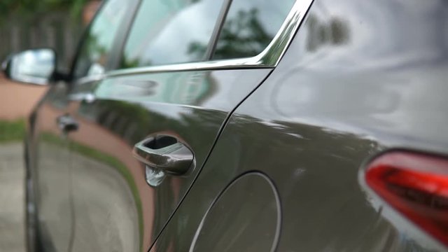 Modern car exterior, dolly shot of the car's headlamp.