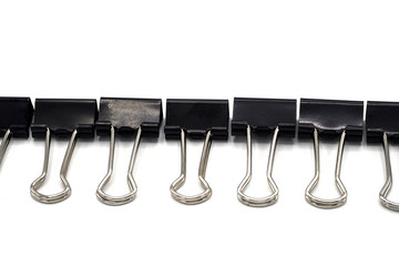 top view of black paper clip solated on white background . Desk office concept.