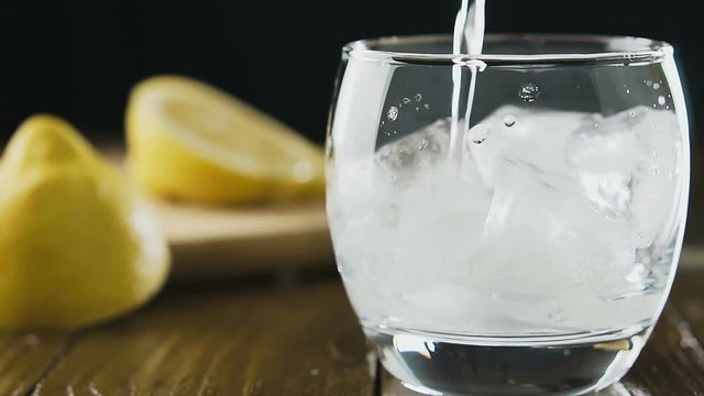 Soda water with ice cubes and lemon in the drink glass.