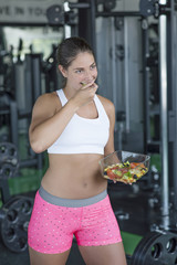Fit woman eating healthy salad after workout