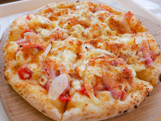 Pizza on wooden tray. Ham, Onion, tomato, cheese delicious yummy pizza.