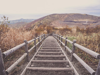Fototapeta na wymiar Wooden stairs on Mt. Usu or Ususan at Hokkaido, Japan. With retro photo filter.