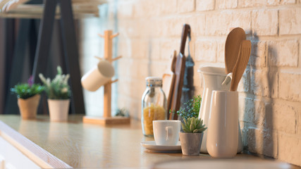 Kitchen utensils and dishware on wooden shelf. Kitchen interior background