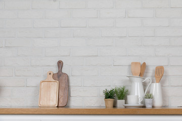 Obraz na płótnie Canvas Kitchen utensils and dishware on wooden shelf. Kitchen interior background