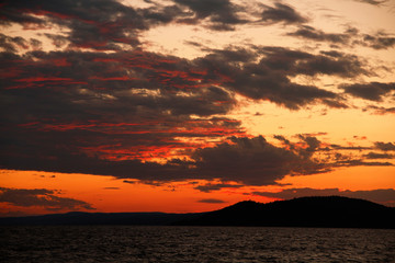 Fototapeta na wymiar Lake Superior sunset with a dark silhouette of mountains