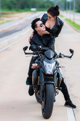 Picture of asian Couple biker with motorcycle on the road,Handsome man and beautiful woman wear black leather for driver on the way,Thailand people,Sweet new couple