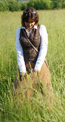 Portrait of a girl in ethnic dress standing in the field grass
