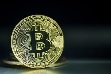 Shiny gold bitcoin on dark background 