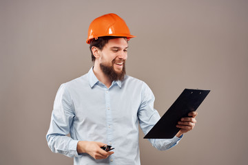 the designer in a helmet smiles looks at the construction documents