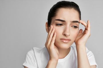 woman with headache on gray background