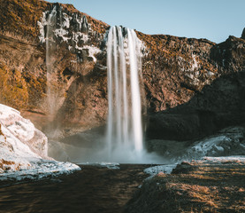Wonderful landscape from Seljalandsfoss Waterfall in Iceland on a clear day with blue sky and snow.