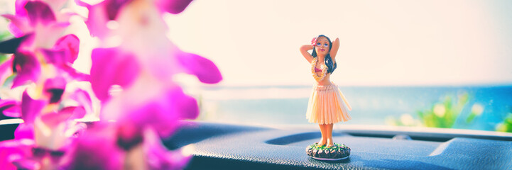 Hula car dashboard road trip Hawaii dancer doll - girl dancing on summer holiday vacation in Maui. with purple flowers lei hanging from mirror. Banner panorama. - obrazy, fototapety, plakaty