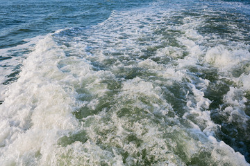 A wave, a trail leaving a boat, a motor ship. Marine background