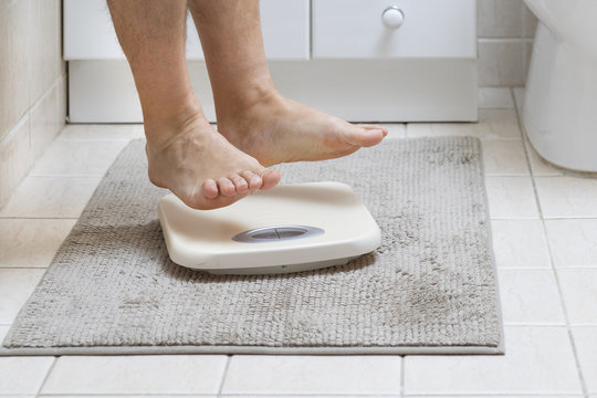 Cropped image of man feet jumping on weigh scale
