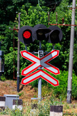 Railroad crossing sign with blinking red lights of semaphore