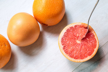 Grapefruit with spoon on a wood table. Close-up.