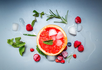 Cocktail drink with grapefruit, berries and ice cubes