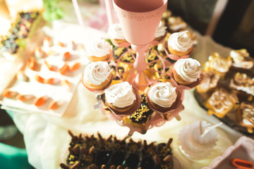 Delicious sweets on wedding candy buffet with desserts, cupcakes