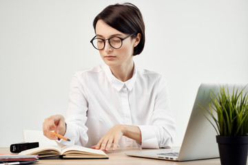 business woman with glasses working on a laptop