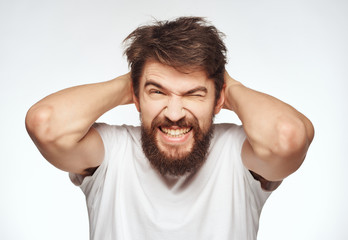 man with a beard is smiling holding hands behind his head