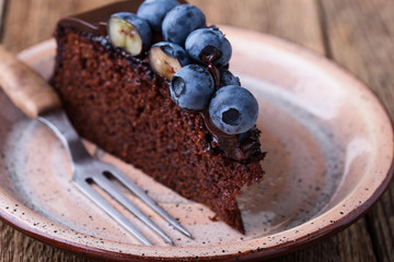 Chocolate cake topped with chocolate glaze and blueberries