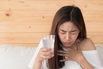 choking woman while drinking water; home danger, health insurance, choking hazard concept; young...