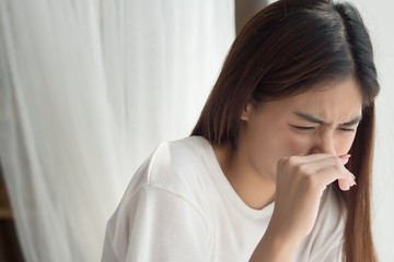 Fototapeta na wymiar sick girl sniffle with runny nose; sick woman suffering from cold, flu, runny nose, trying to clear her nose; woman personal health care, pain, sickness concept; asian young adult woman model