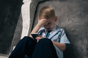 kid sitting on the floor and playing with smart phone